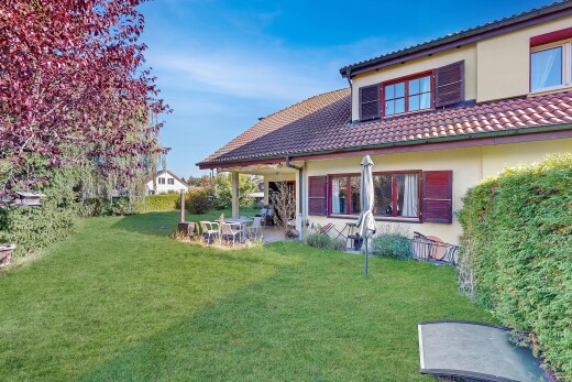 außenansicht mit terrasse, rasen, property visible, stuckverkleidung, und day time