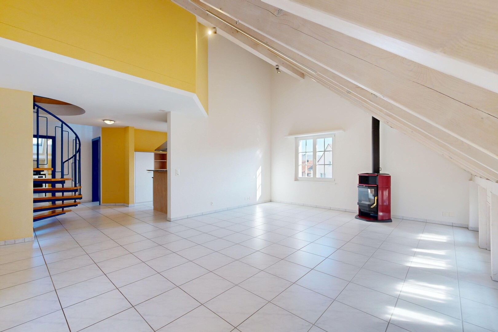 pièce vide avec plafond voûté, vaulted ceiling, escaliers, poêle à bois, et inside property