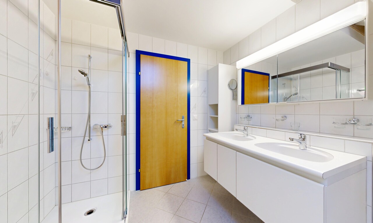 salle de bains avec double vasque, mur en carrelage, tile wall, douche, et light floor