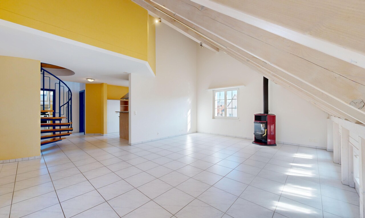 pièce vide avec plafond voûté, vaulted ceiling, escaliers, poêle à bois, et inside property