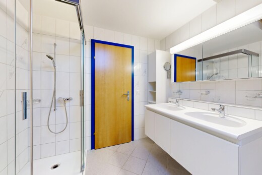 salle de bains avec double vasque, mur en carrelage, tile wall, douche, et light floor