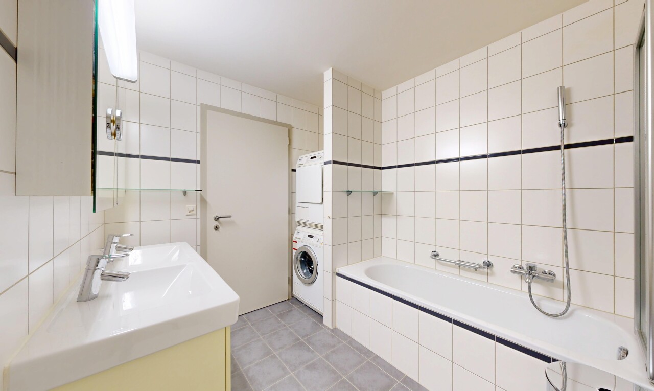 salle de bains avec mur en carrelage, tile wall, double vasque, miroir, et salle de bain complète
