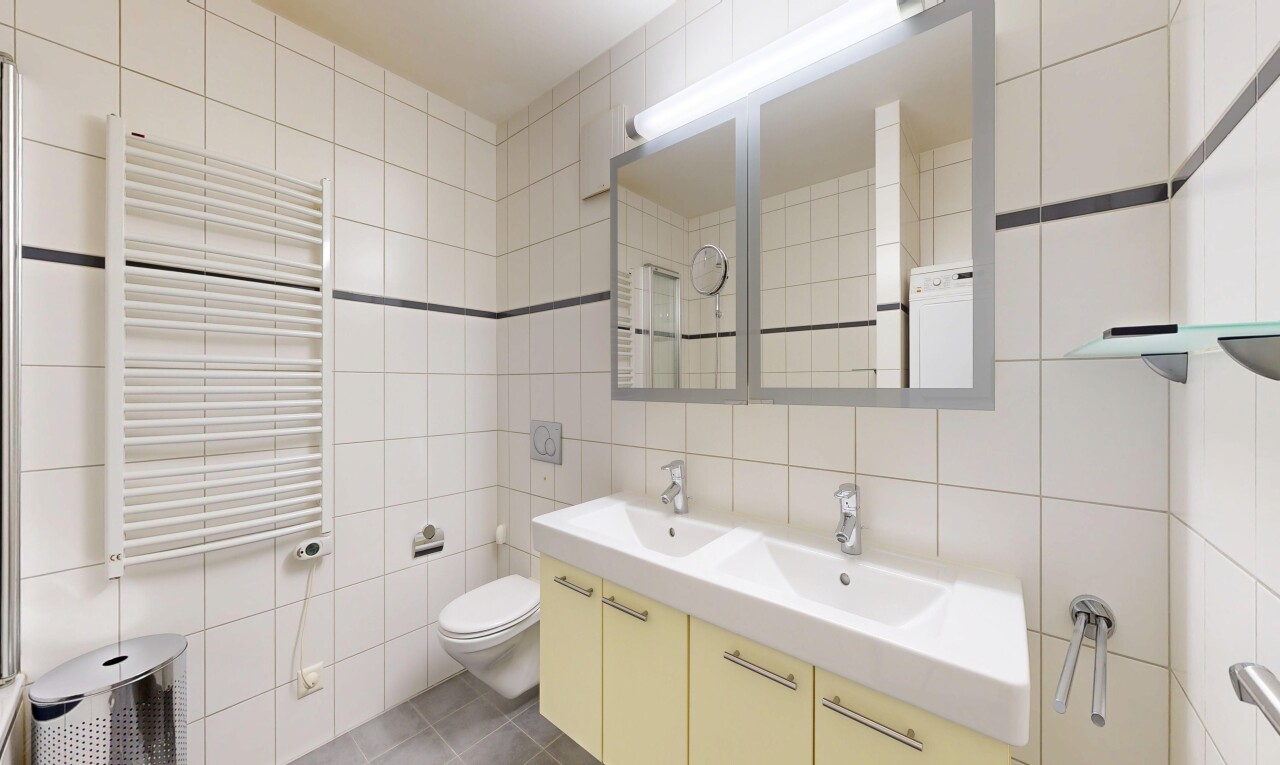 salle de bains avec chauffe-serviettes, radiateur, mur en carrelage, tile wall, et double vasque