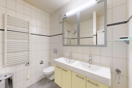 salle de bains avec chauffe-serviettes, radiateur, mur en carrelage, tile wall, et double vasque