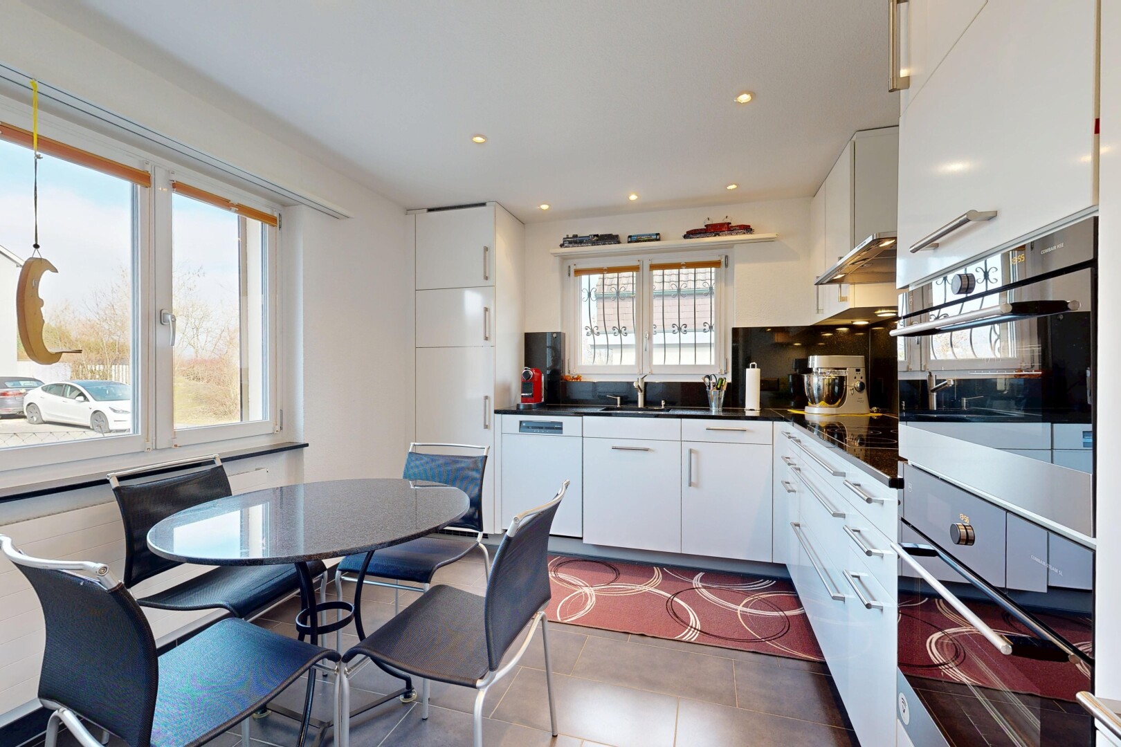 cuisine avec armoires blanches, white cabinets, inside property, dark countertops, et cloison sèche