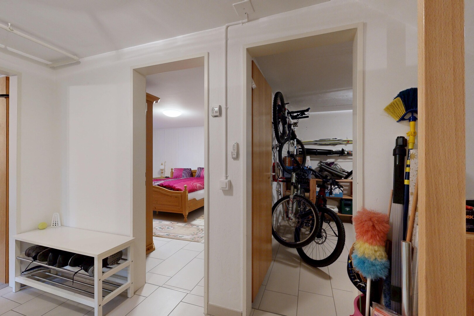 couloir avec inside property, cloison sèche, drywall, escaliers escamotables, et sol en carrelage