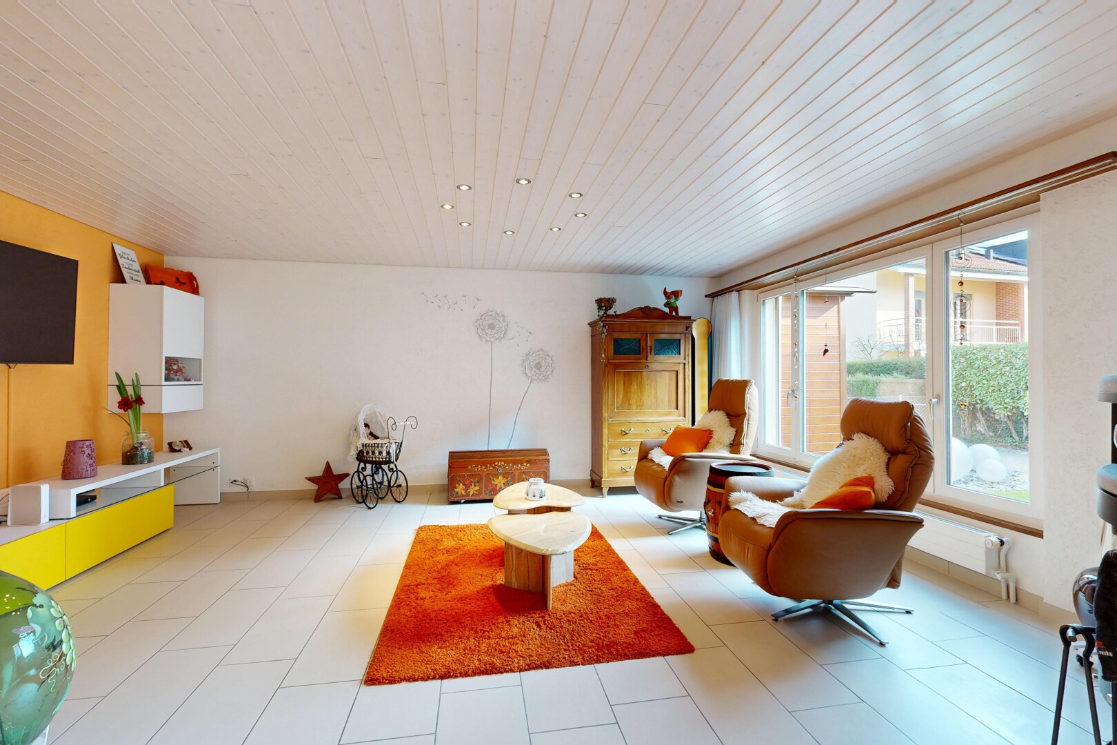 salon avec inside property, télévision, cloison sèche, drywall, et lumière naturelle