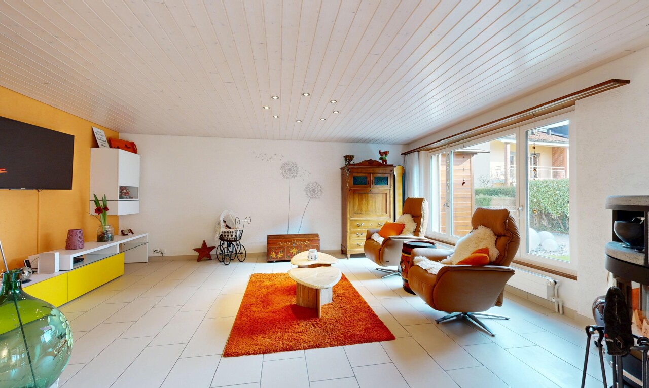 salon avec inside property, télévision, cloison sèche, drywall, et lumière naturelle