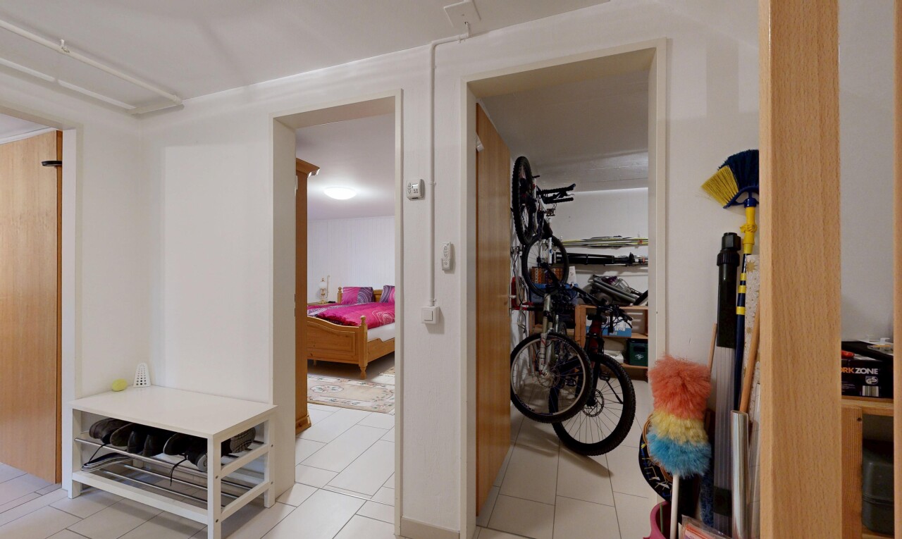 couloir avec inside property, cloison sèche, drywall, escaliers escamotables, et sol en carrelage