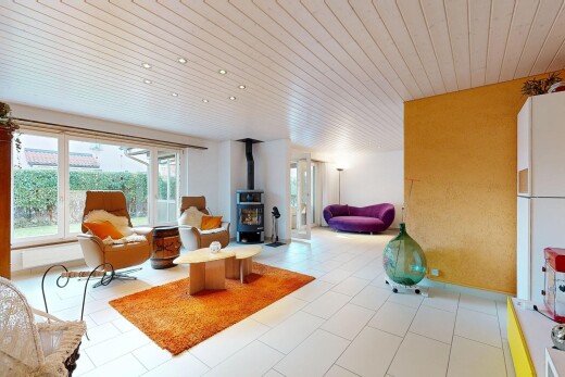 salon avec plafond en bois, wood ceiling, poêle à bois, lumière naturelle, et natural light