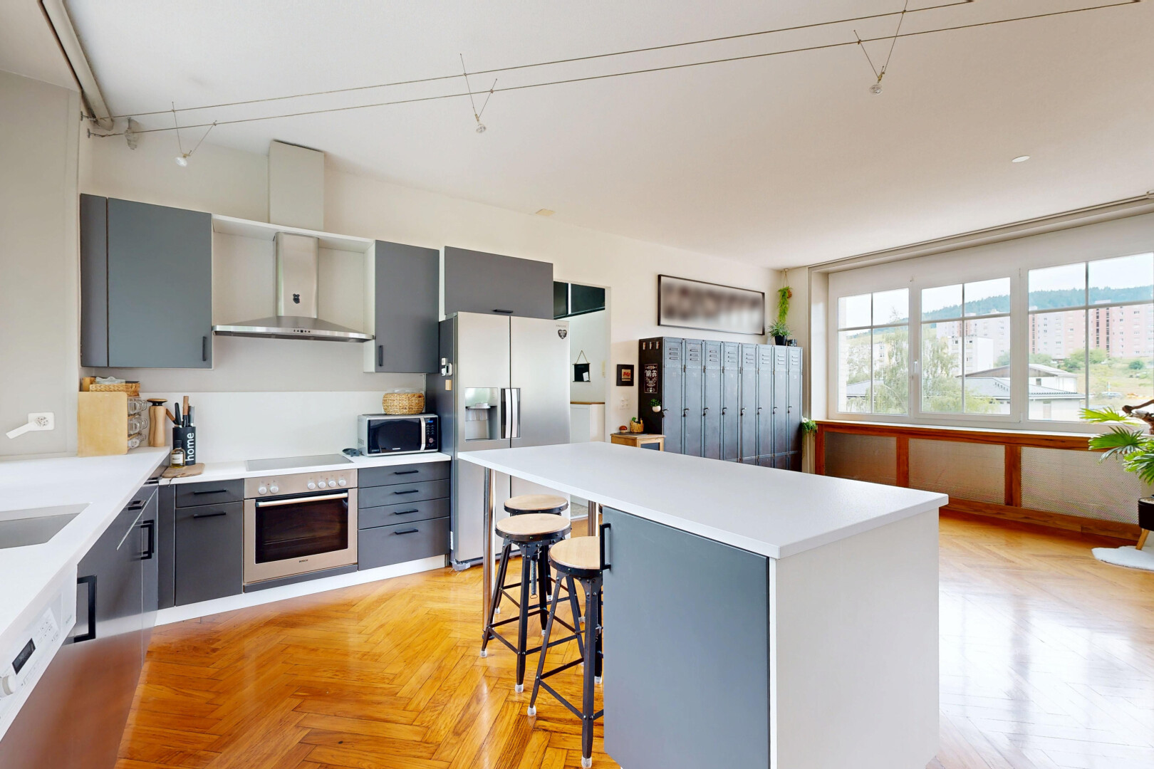 cuisine avec gray cabinets, armoires grises, parquet floor, réfrigérateur, et inside property