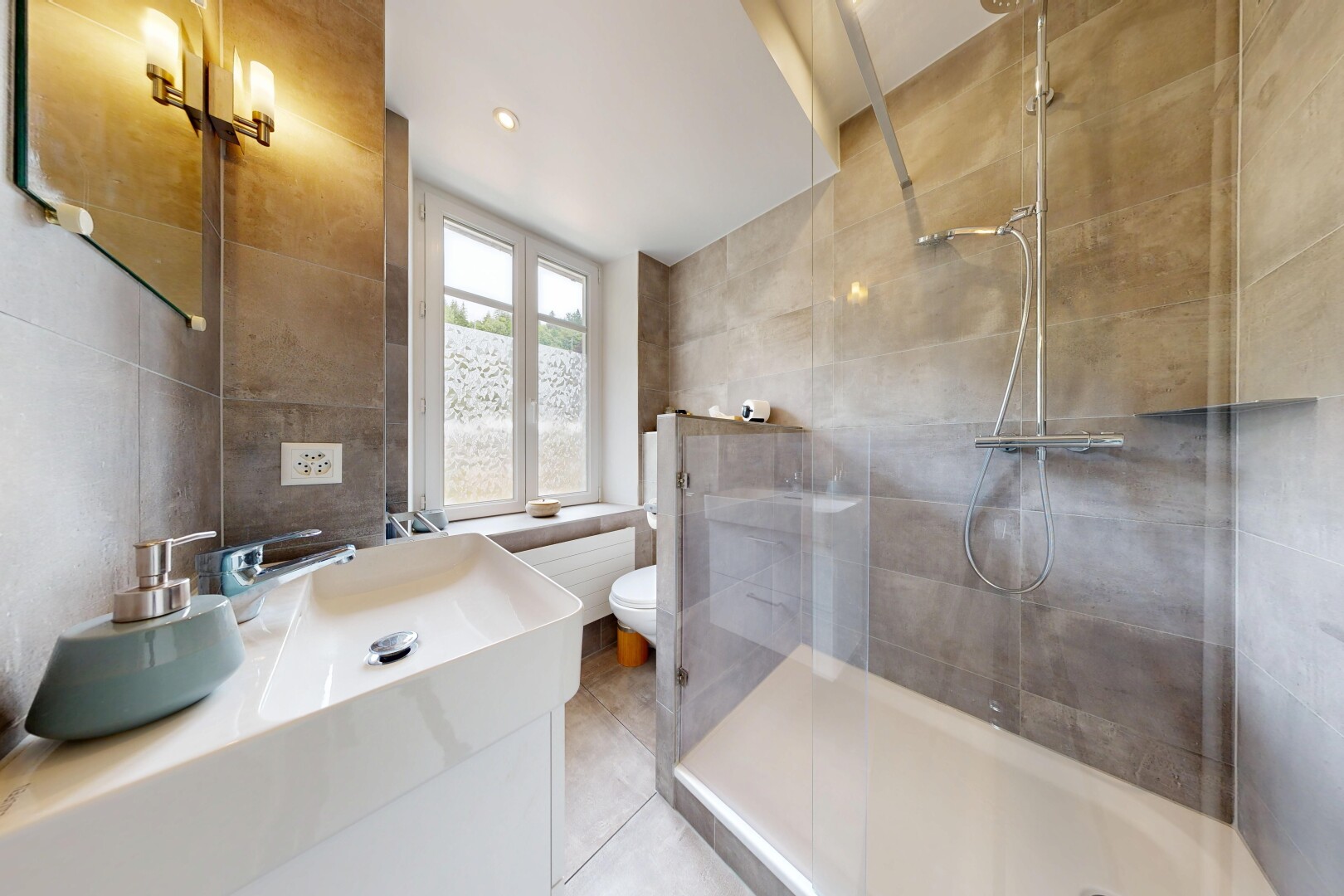 salle de bains avec mur en carrelage, tile wall, miroir, lavabo (ou coiffeuse selon le contexte), et douche