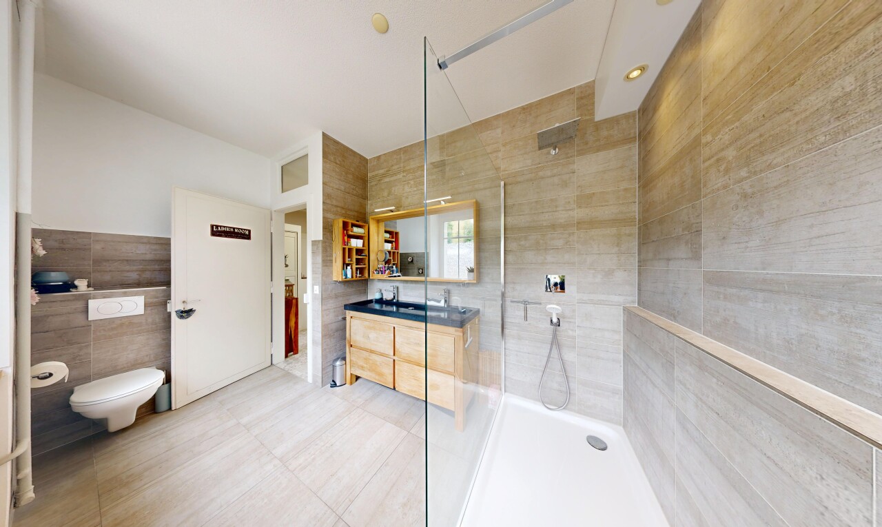 salle de bains avec tile wall, mur en carrelage, lavabo (ou coiffeuse selon le contexte), miroir, et salle de bain complète