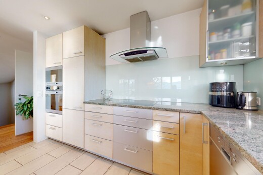 kitchen featuring ventilation hood, oven, light stone counters, and glass insert cabinets