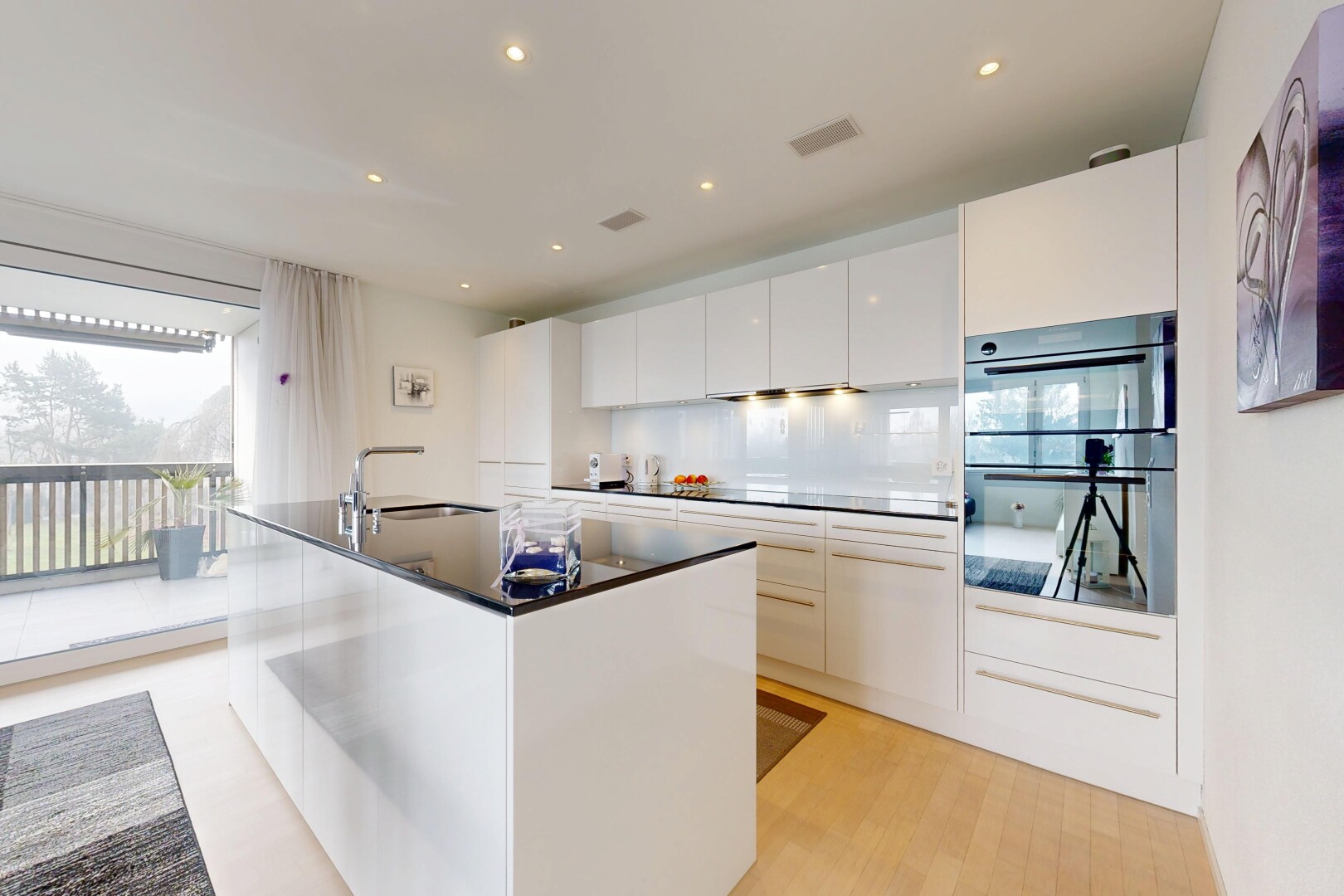 kitchen with white cabinets, modern cabinets, double wall oven, a center island with sink, and recessed lighting