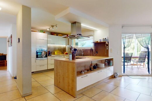 cuisine avec hotte, four, dosseret, backsplash, et lumière naturelle