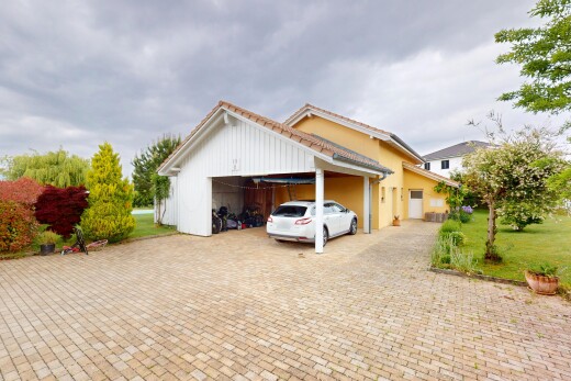 façade avec garage attaché, overcast, property visible, et allée