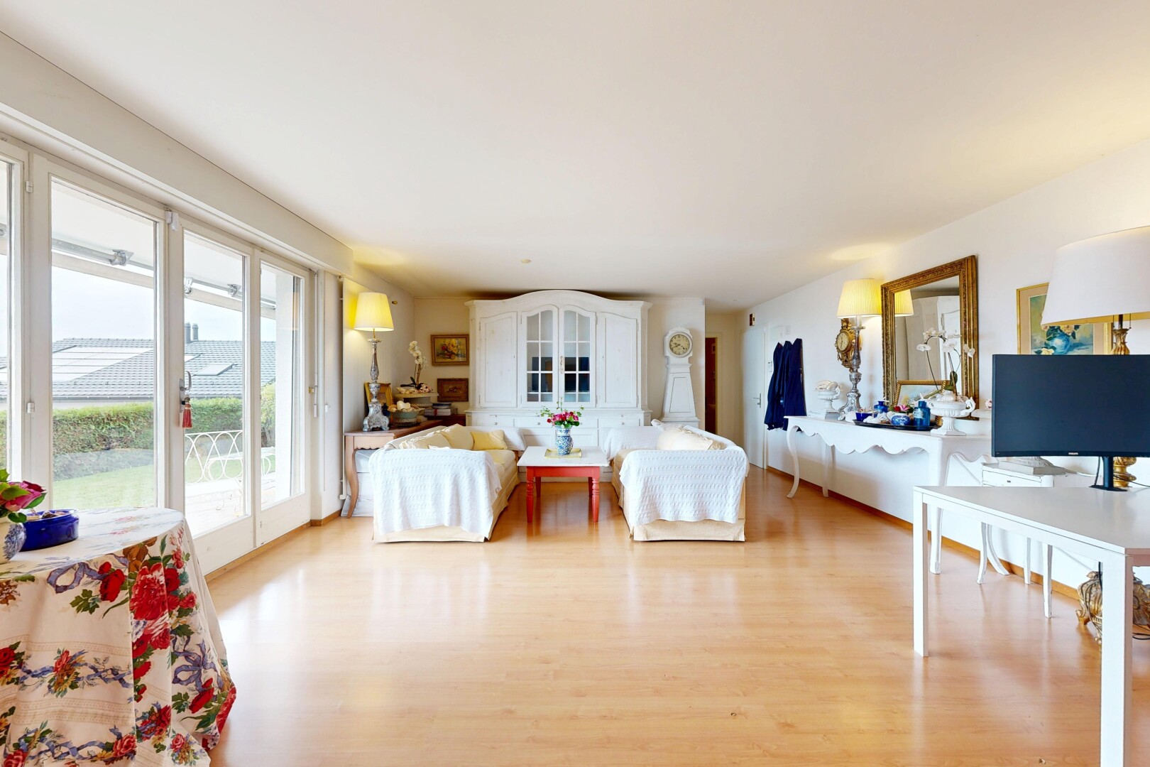 salon avec inside property, wood finish floor, sol en finition bois, télévision, et natural light