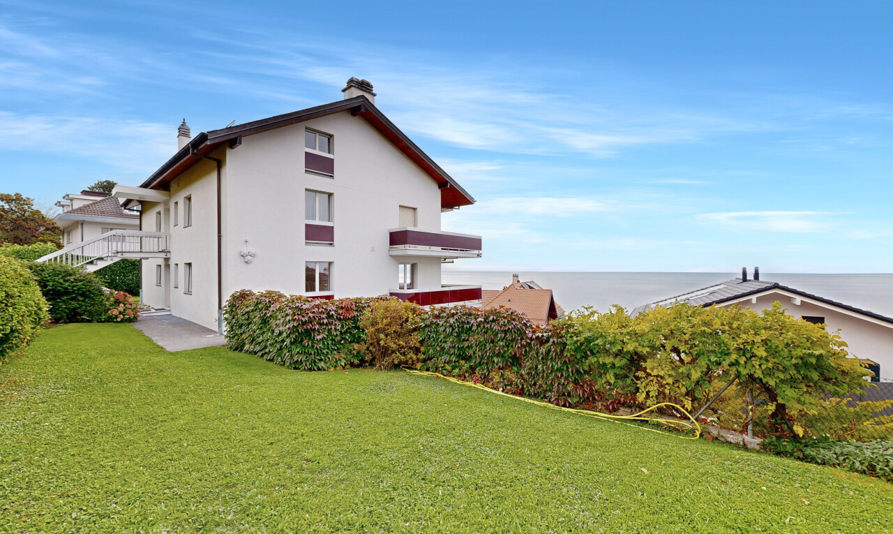 façade avec day time, pelouse, property visible, bardage en stuc, et ocean view