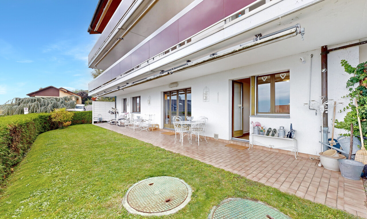 façade avec terrasse, bardage en stuc, day time, property visible, et pelouse