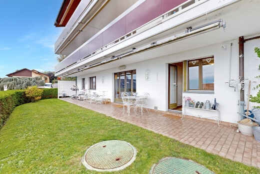 façade avec terrasse, bardage en stuc, day time, property visible, et pelouse