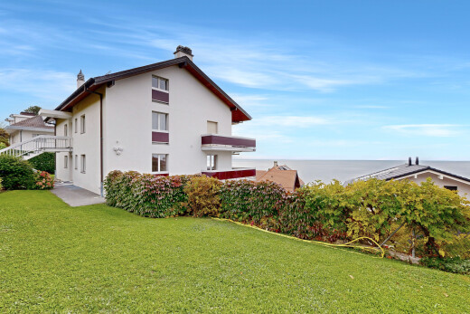 façade avec day time, pelouse, property visible, bardage en stuc, et ocean view