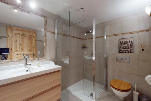 salle de bain avec mur carrelé, carrelage, miroir, meuble-lavabo, et douche
