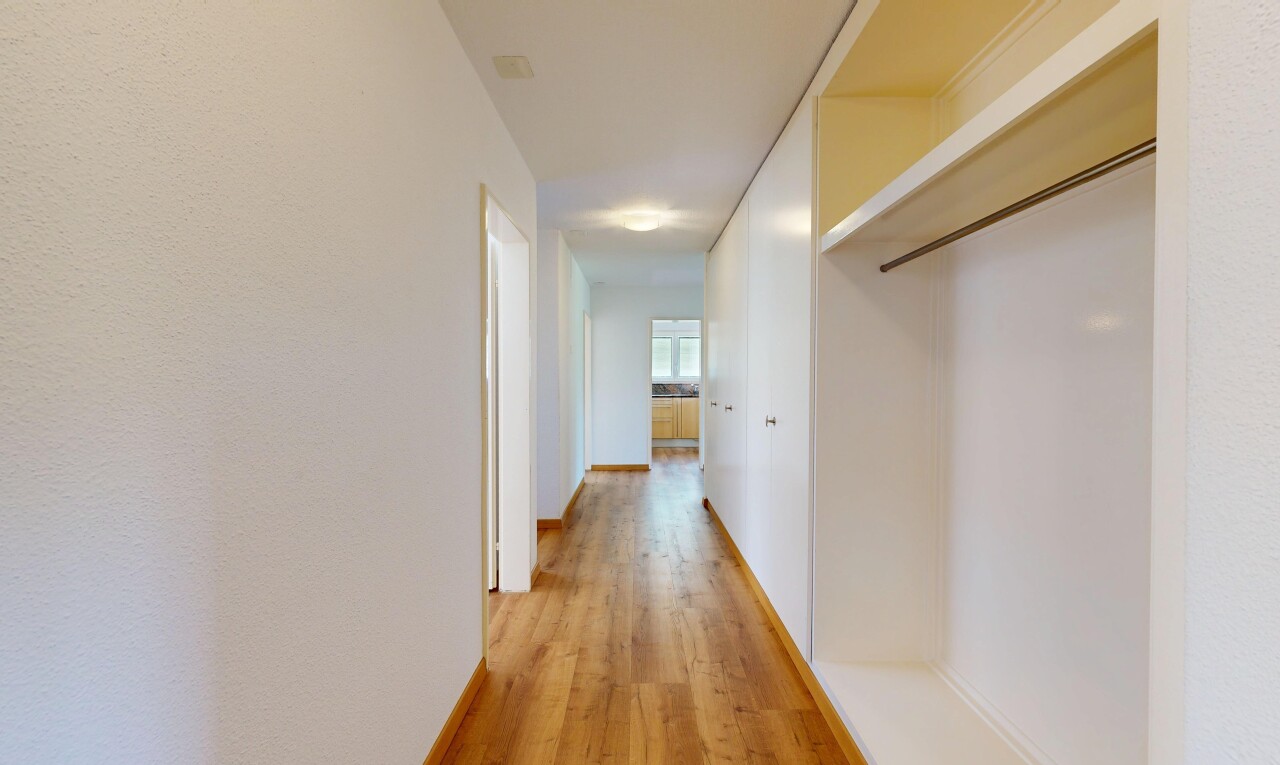 hall featuring light wood-type flooring and baseboards