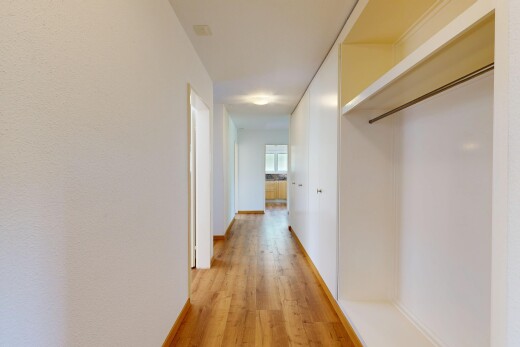 hall featuring light wood-type flooring and baseboards