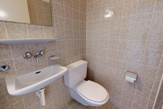 half bathroom with toilet and tile walls