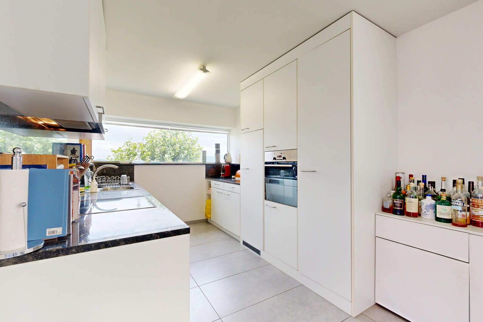 cuisine avec inside property, white cabinets, armoires blanches, light floor, et drywall