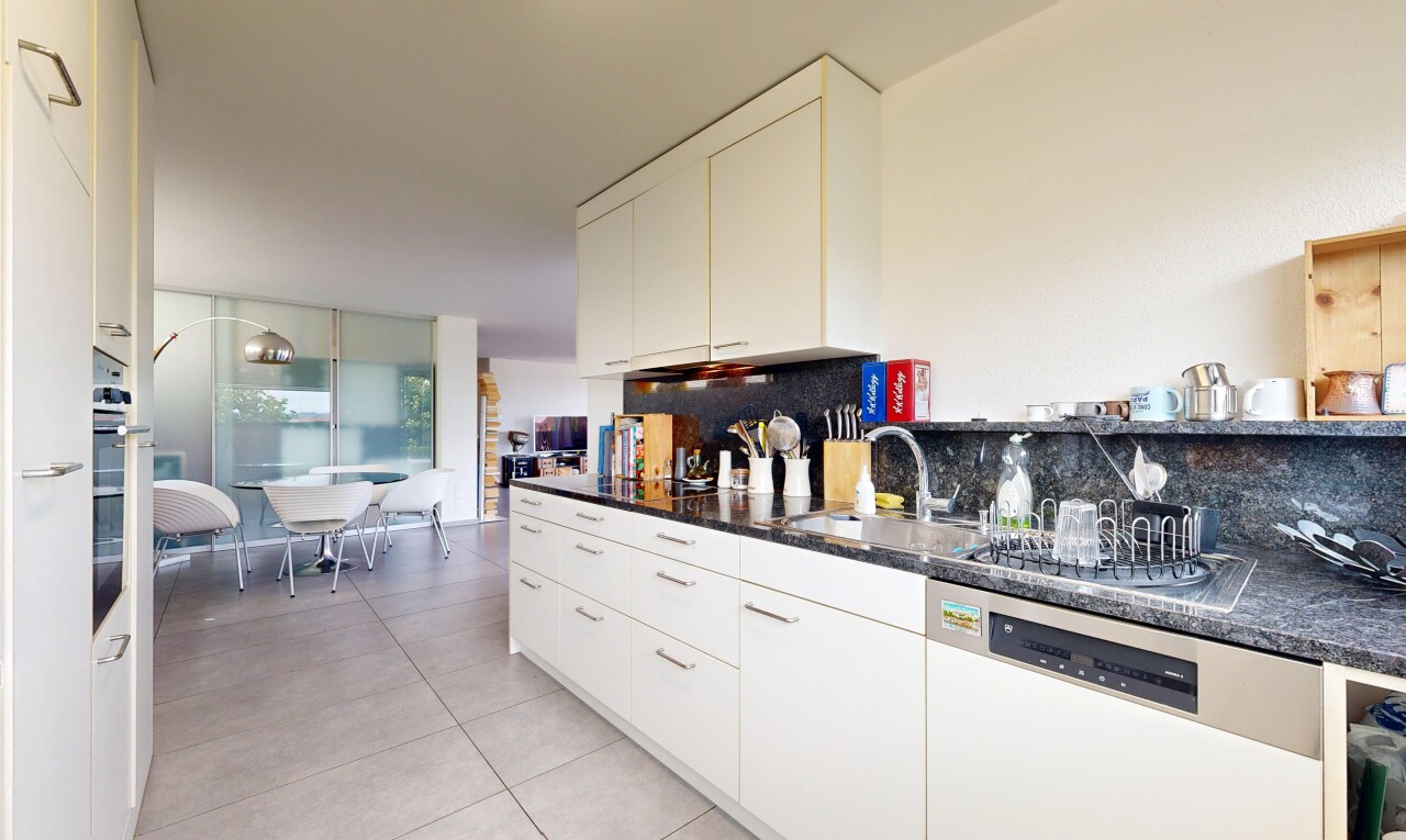 cuisine avec lave-vaisselle, dark countertops, light floor, backsplash, et dosseret