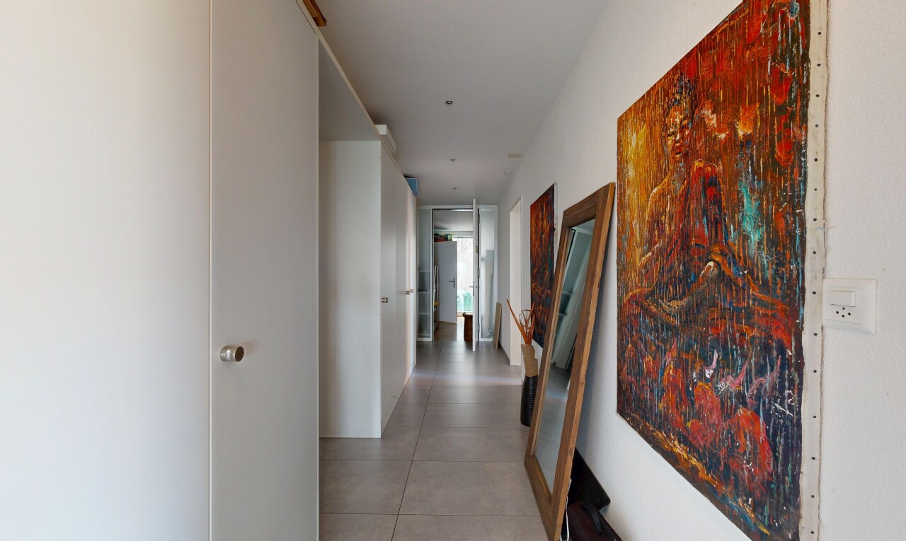 couloir avec inside community, drywall, cloison sèche, et light floor