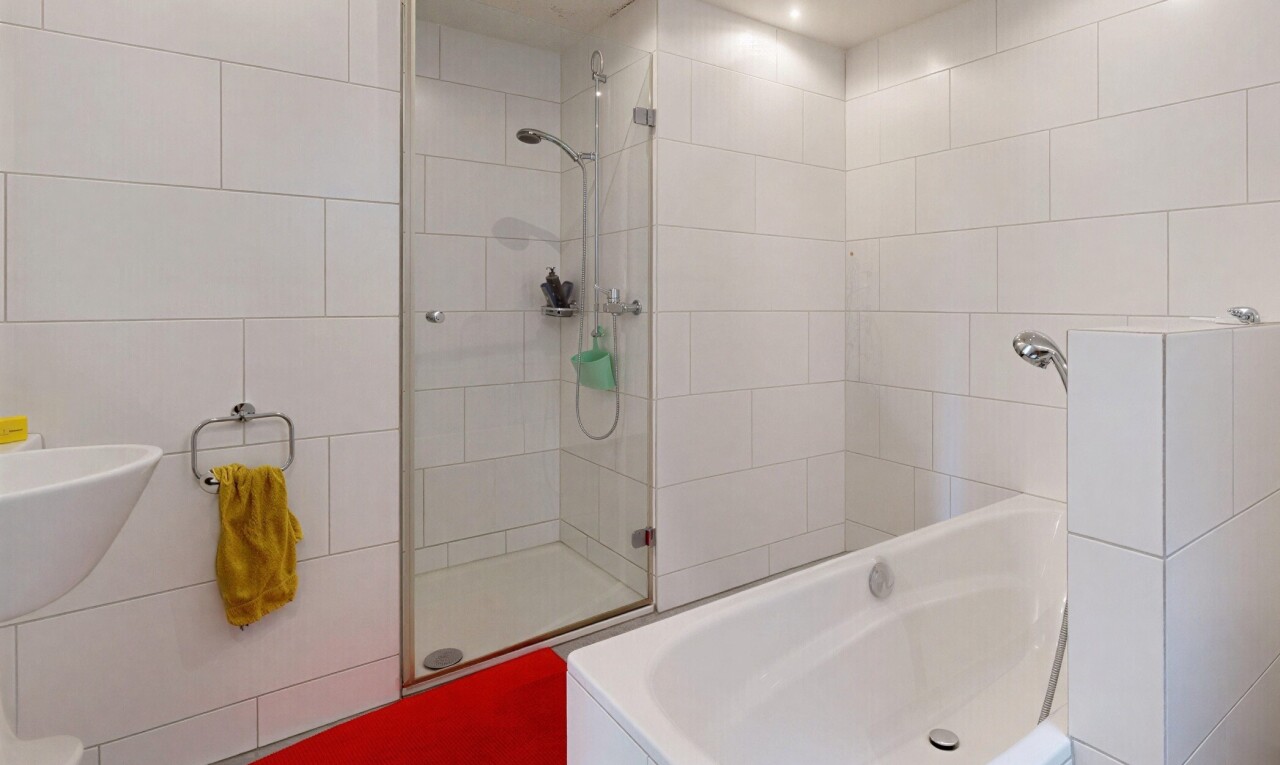 salle de bains avec tile wall, mur en carrelage, douche, salle de bain complète, et inside property