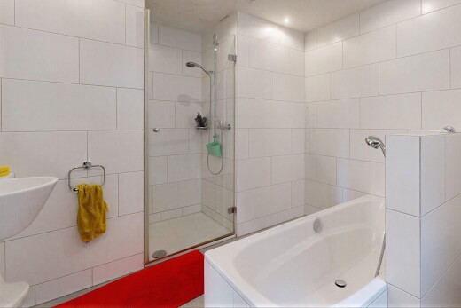 salle de bains avec tile wall, mur en carrelage, douche, salle de bain complète, et inside property