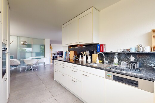 cuisine avec lave-vaisselle, dark countertops, light floor, backsplash, et dosseret