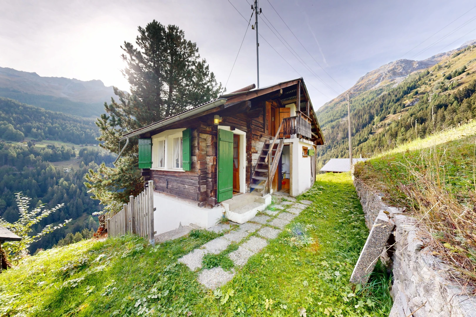 façade avec mountain view, vue sur la montagne, property visible, power lines view, et escaliers