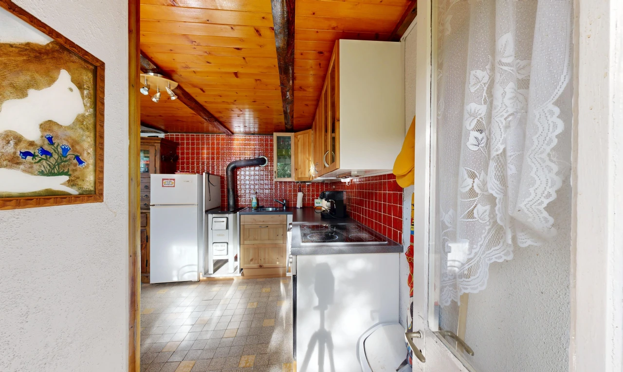 cuisine avec plafond en bois, wood ceiling, réfrigérateur, plans de travail, et dark countertops