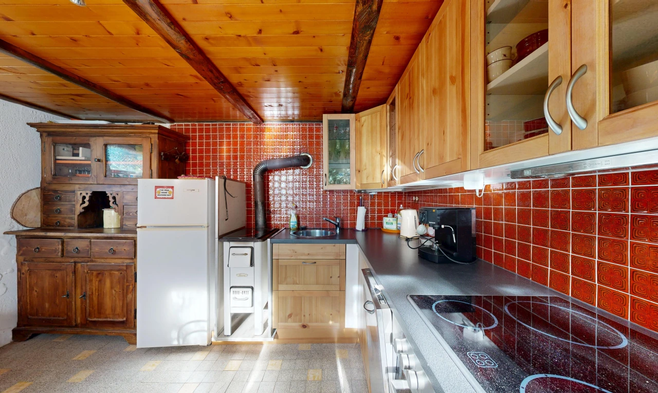 cuisine avec armoires avec insert en verre, glass insert cabinets, plaque de cuisson, plans de travail, et dark countertops