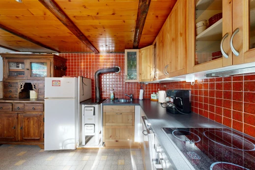 cuisine avec armoires avec insert en verre, glass insert cabinets, plaque de cuisson, plans de travail, et dark countertops
