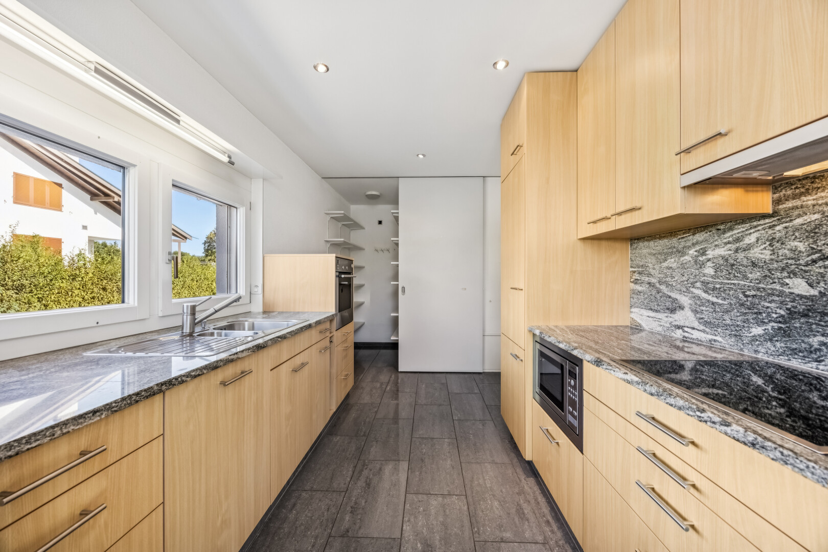 küche mit dark floor, light brown cabinets, hellbraune schränke, stone countertops, und stein arbeitsplatten