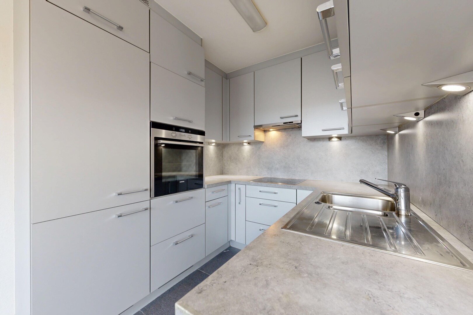 küche mit arbeitsplatten, light countertops, ofen, inside property, und küchenrückwand beim herd