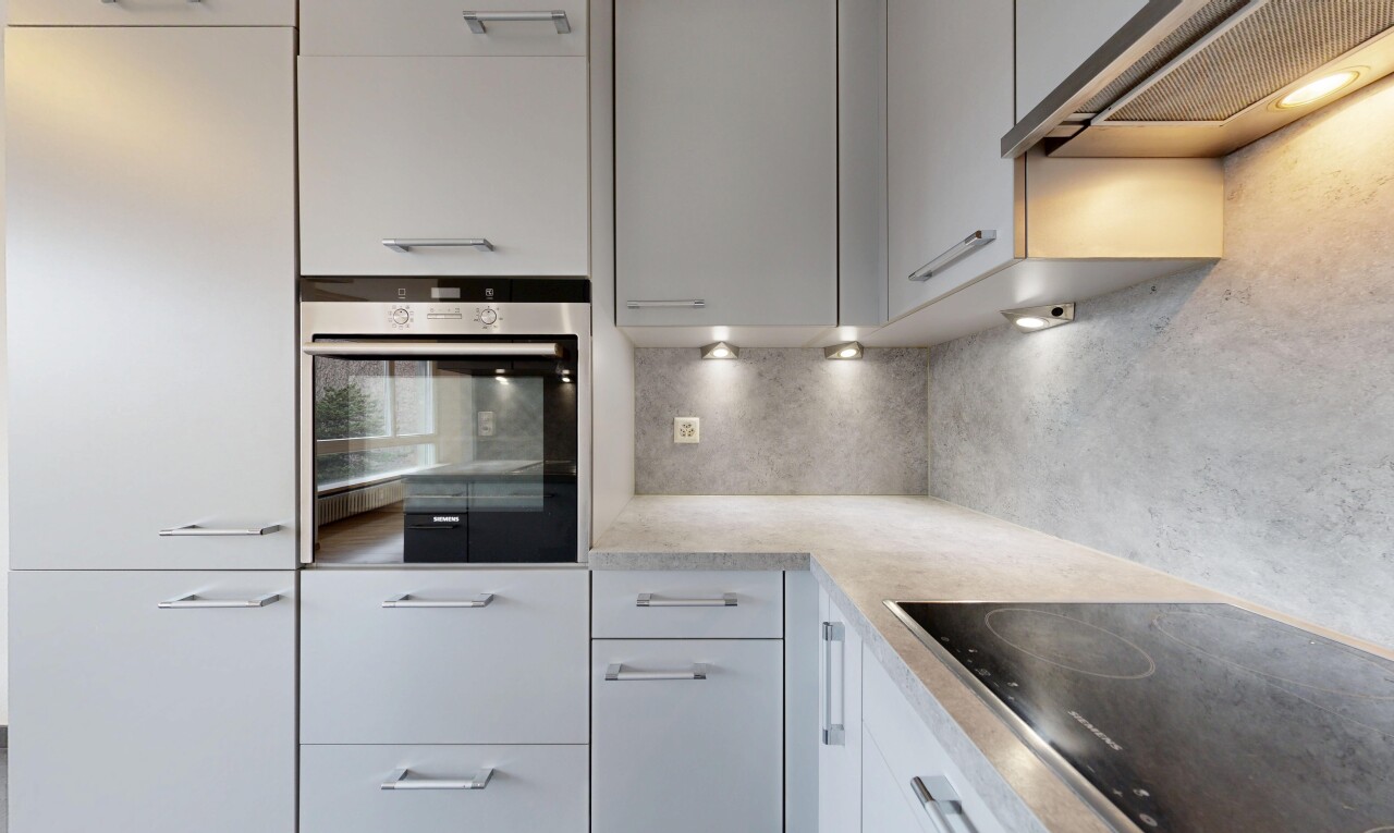 küche mit dunstabzugshaube, herd, ofen, light countertops, und inside property