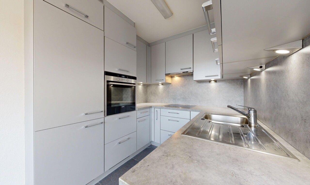 küche mit arbeitsplatten, light countertops, ofen, inside property, und küchenrückwand beim herd