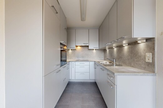 cuisine avec light countertops, plans de travail, dark floor, inside property, et tile floor