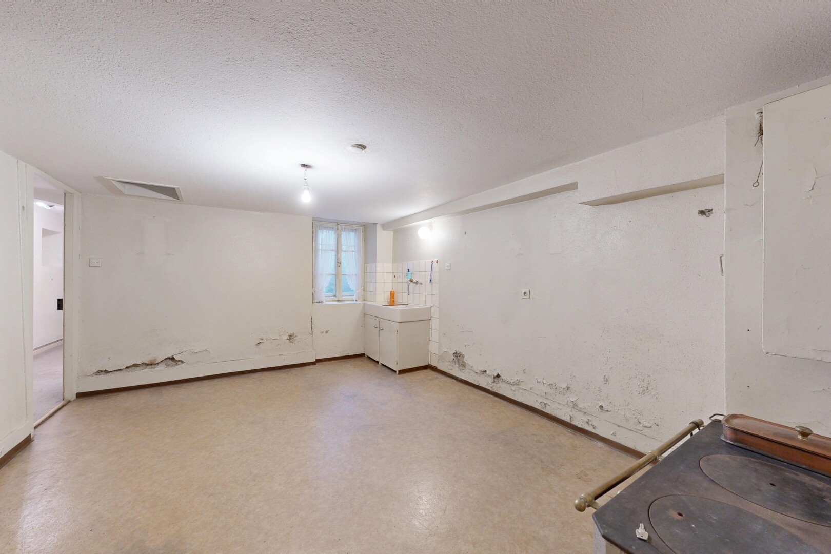 pièce vide avec plafond texturé, textured ceiling, sous-sol, inside property, et lumière naturelle