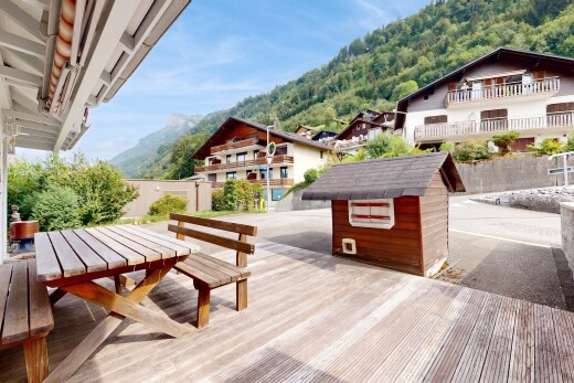 terrace with outdoor dining space, a mountain view, and an outbuilding