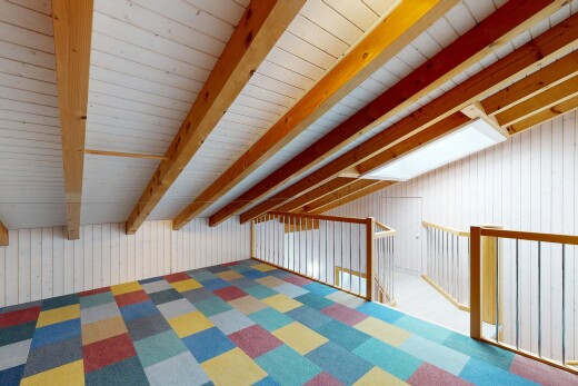 empty room with wood walls and lofted ceiling with beams