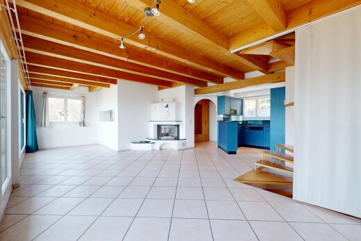 unfurnished living room with rail lighting, a fireplace with raised hearth, a wooden ceiling with exposed beams, arched walkways, and light tile patterned floors