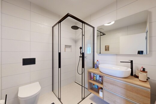 salle de bains avec mur en carrelage, tile wall, lavabo (ou coiffeuse selon le contexte), salle de bain complète, et douche